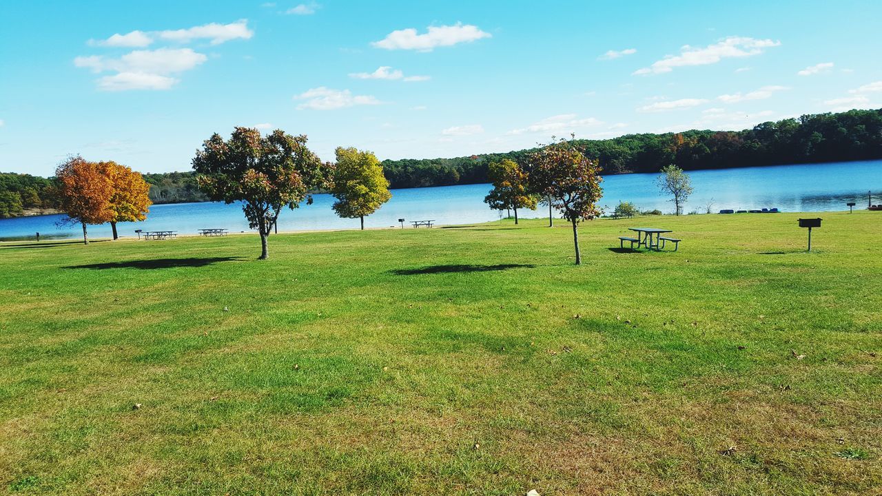 tranquil scene, tranquility, sky, grass, tree, scenics, water, beauty in nature, nature, lake, growth, landscape, idyllic, cloud - sky, green color, field, cloud, blue, grassy, non-urban scene