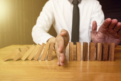 Close-up of man holding cigarette on table