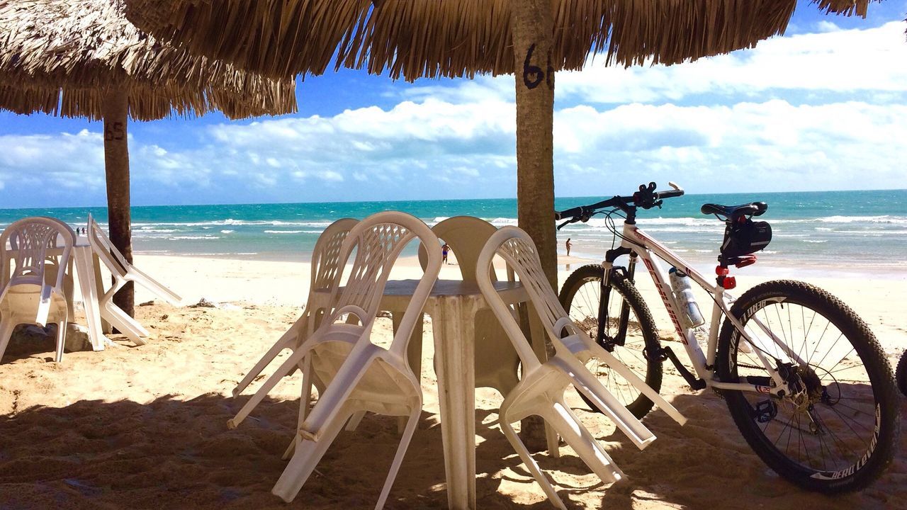 beach, sea, horizon over water, water, shore, sand, thatched roof, sunlight, transportation, tranquil scene, sky, scenics, blue, mode of transport, tropical climate, non-urban scene, tranquility, summer, remote, coastline, vacations, nature, outdoors, beauty in nature, calm, day, tourism