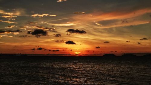 Scenic view of sea against dramatic sky during sunset