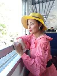 Smiling woman looking through window from train