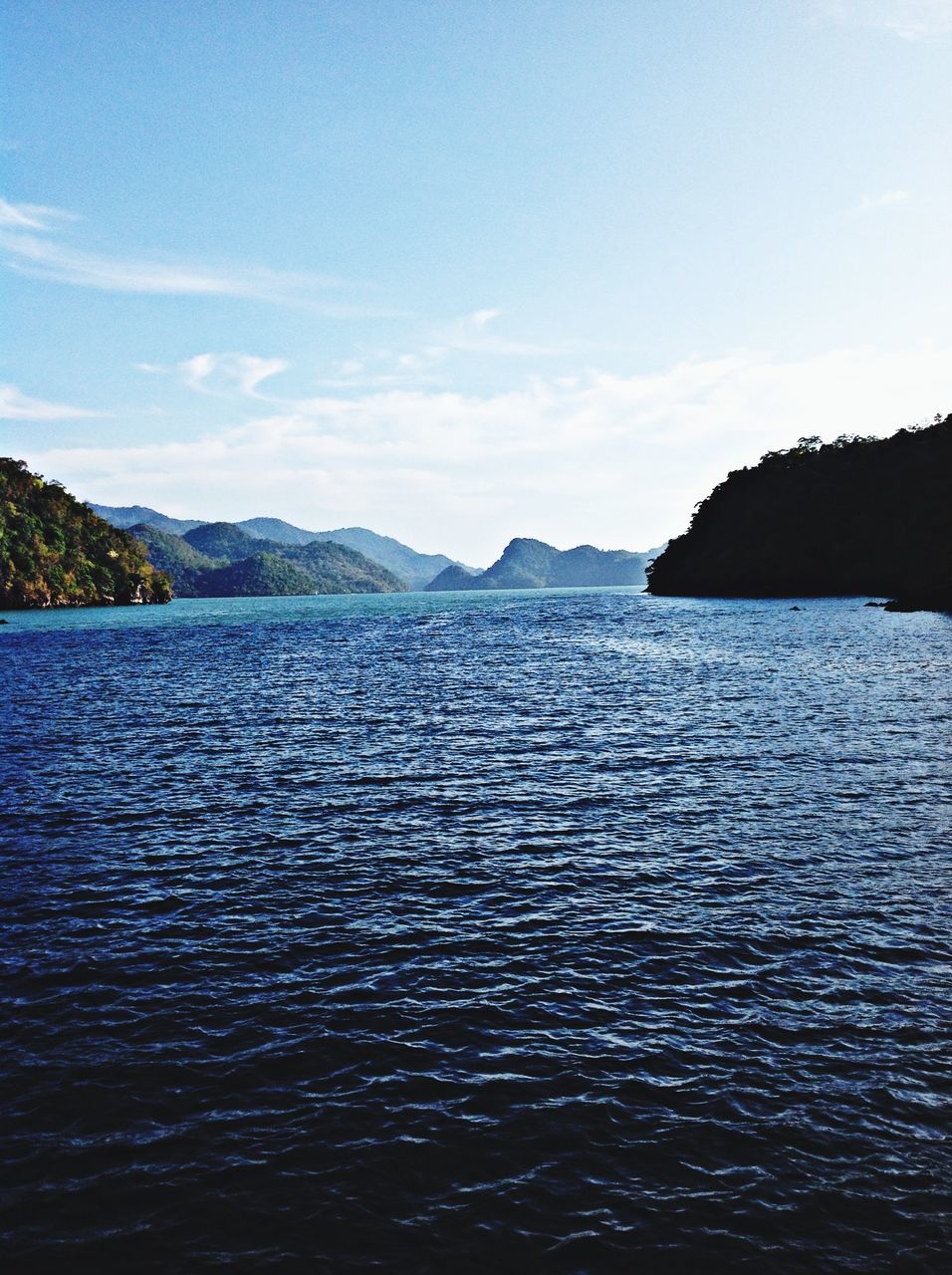 water, mountain, tranquil scene, scenics, waterfront, sky, tranquility, sea, beauty in nature, rippled, nature, mountain range, blue, idyllic, cloud, cloud - sky, calm, non-urban scene, outdoors, lake