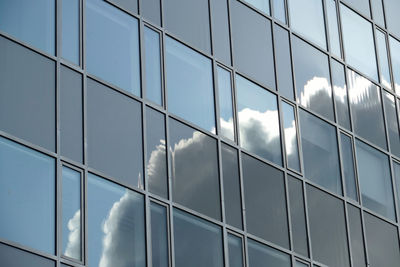 Low angle view of glass building against sky