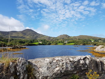 Scenic view of lake by mountain against sky