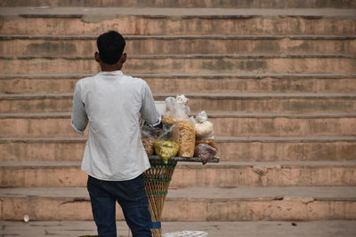 Rear view of man standing against wall