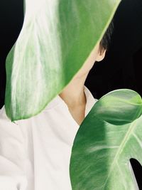 Close-up of woman with green leaves