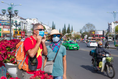 People on road in city against sky