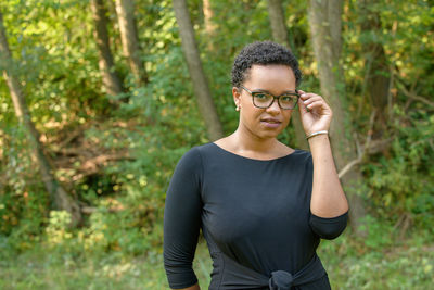 A young pretty african american businesswoman in a park with summer temperatures.