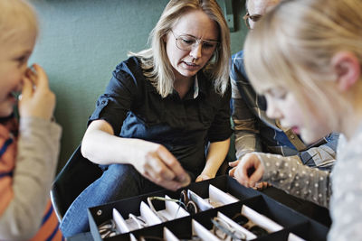 Family arranging eyeglasses in box at workshop