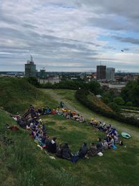 People sitting at park against sky