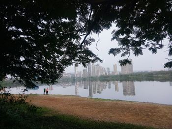 Man standing by lake against sky