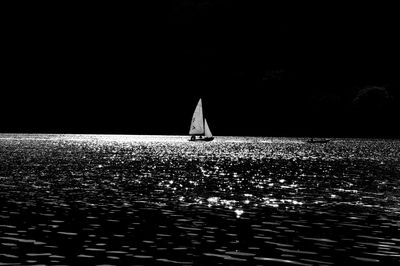 Sailboat sailing on sea against clear sky at night