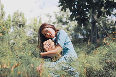 Young woman smiling while sitting on land