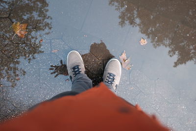 Low section of man standing in puddle