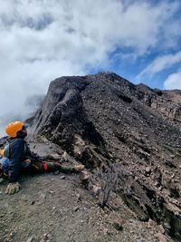 Rear view of woman walking on mountain against sky