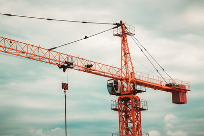 Low angle view of crane against sky