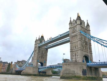 Low angle view of bridge against cloudy sky