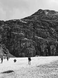 Full length of man standing on rock against sky
