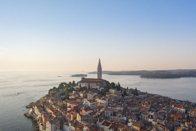 Panoramic view of sea and buildings against sky during sunset