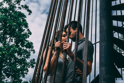 Low angle view of couple standing in the cage