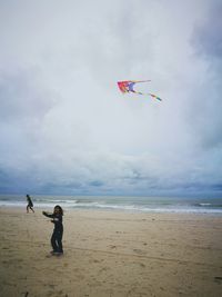 Boy on beach against sky