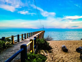 Wooden posts on beach against sky