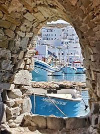 Buildings by sea seen through arch window