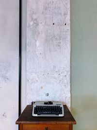 Telephone booth on table against wall