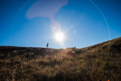 Woman on field against bright sun