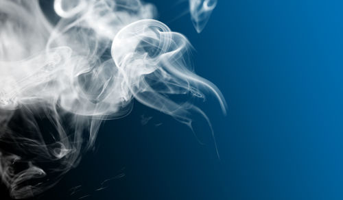 Close-up of smoke against blue background