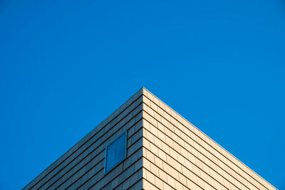 Low angle view of office building against clear blue sky