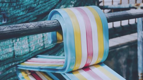 Close-up of multi colored clothing hangers on railing