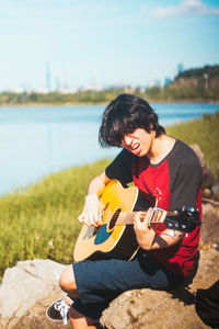 Young woman sitting on guitar