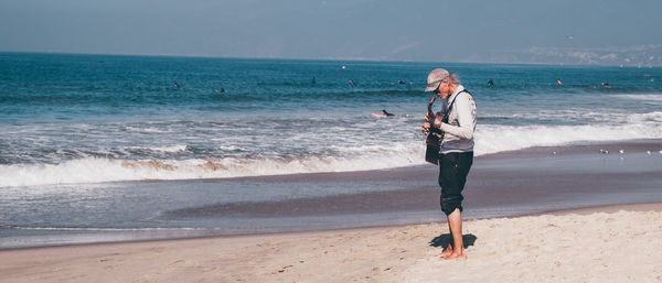 Full length of boy on beach against sky