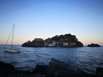 Sailboats in sea against clear sky