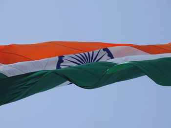 Low angle view of flags against clear blue sky