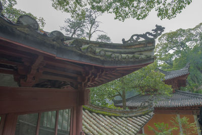 Temple by building against sky