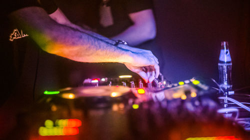 Close-up of hand playing illuminated at music concert