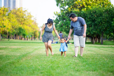 Family walking on lawn in park