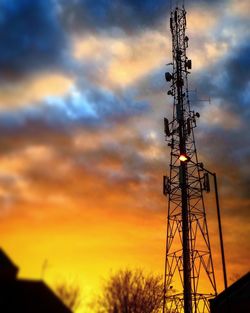 Low angle view of silhouette electricity pylon against sky during sunset