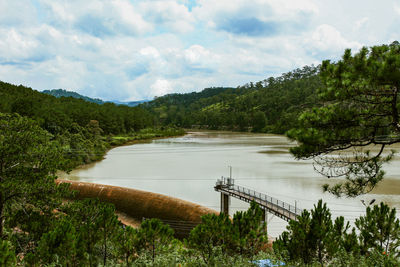 Scenic view of river by trees against sky