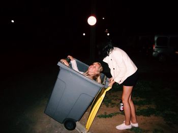 Women playing with recycling bin