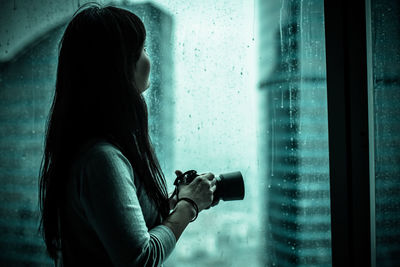 Woman by wet window 