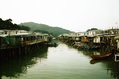 Boats moored on river against clear sky