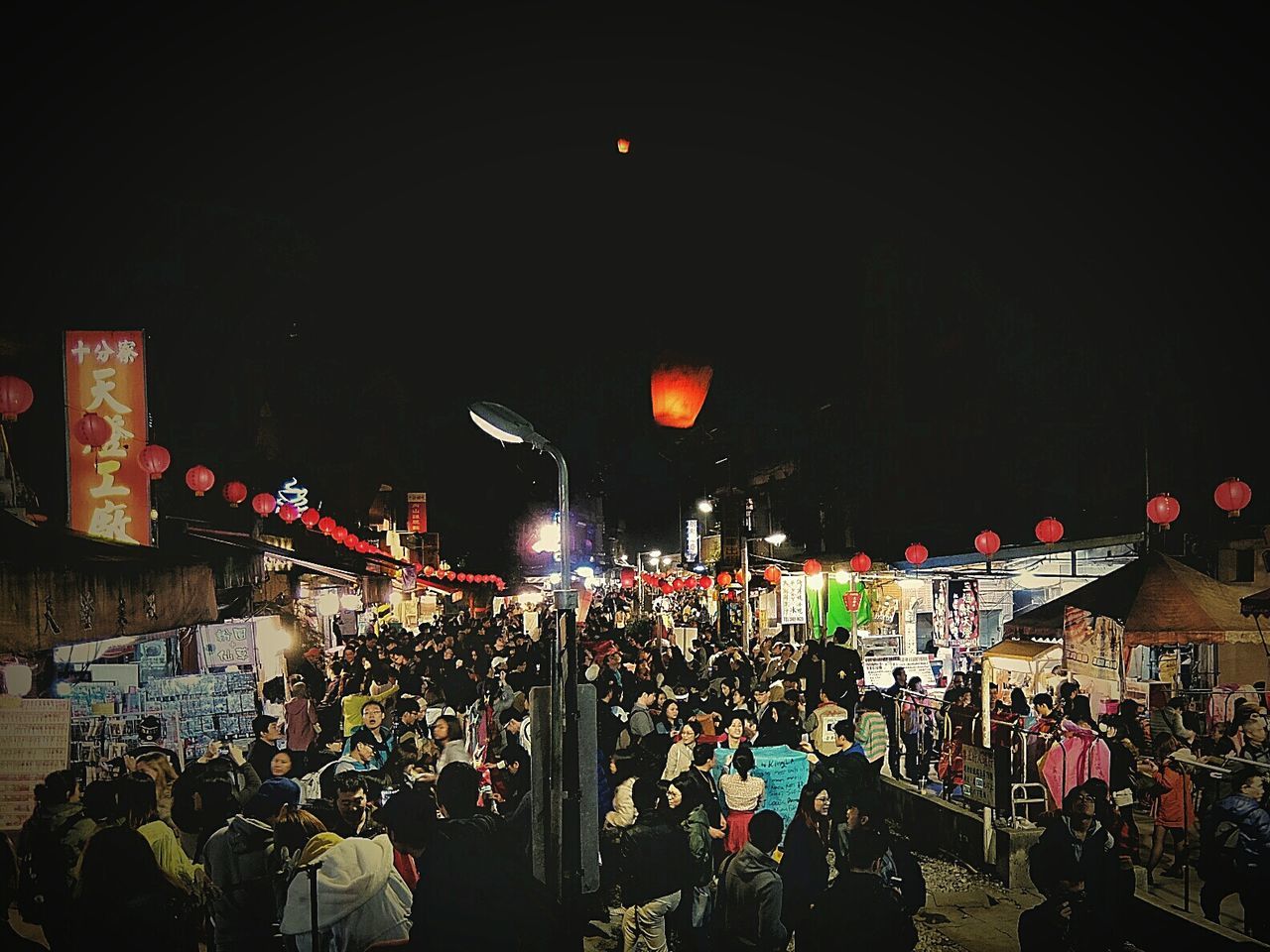 People at night market against sky