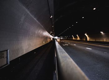 Road passing through illuminated tunnel