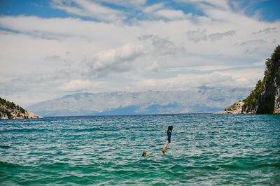 Woman swimming in sea against sky