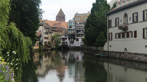 River by buildings in city against sky