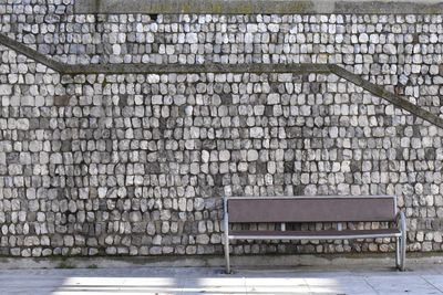 Empty bench against wall
