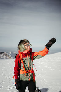 Portrait of smiling young woman standing on snow